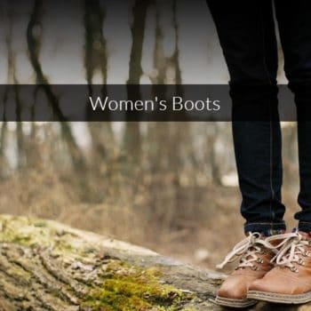 pic of a womens legs from just above the knee, down,wearing black pants and brown hiking boots, standing on a tree