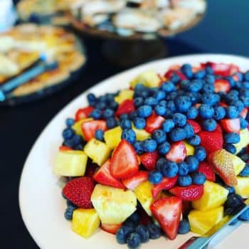 A plate of strawberries, blueberries, and pineapple.