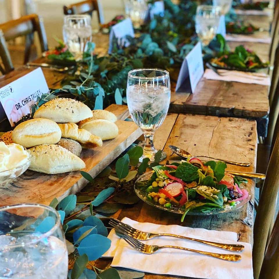 Table set at an event; likely a wedding. Bread and salad are on the table.