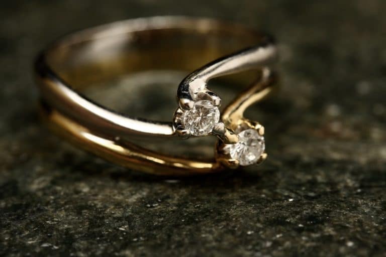 two gold solitair rings stacked on top of each other,
