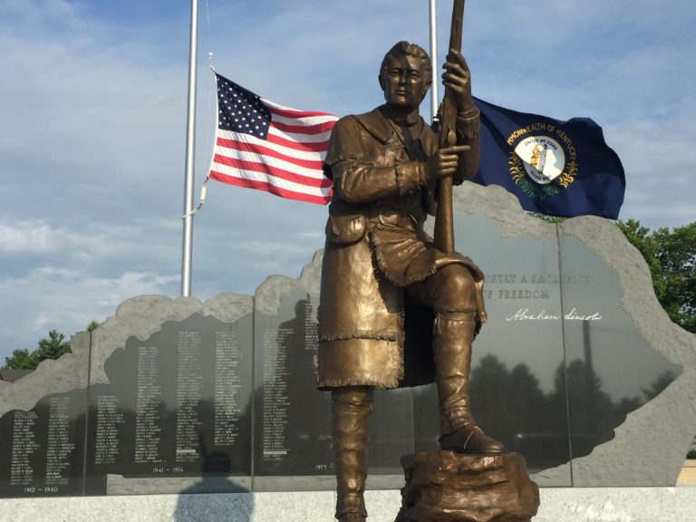 image of monument with flags lowered half staff for Memorial Day