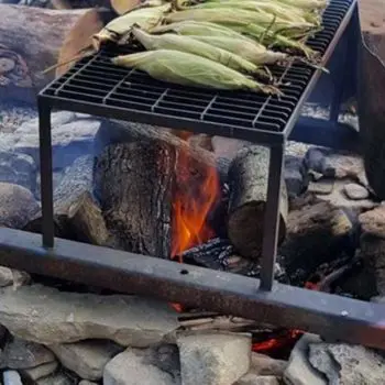 close up shot of a fire with corn cobs roasting on a grill close up shot of a fire with corn cobs roasting on a grill