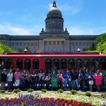 Trolley outside Capitol with people standing outside of it